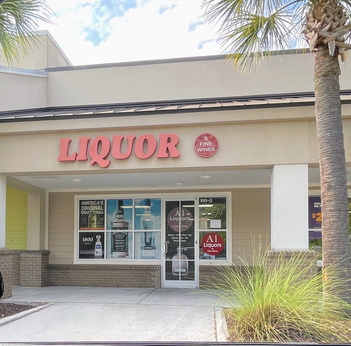 A1 Liquors in Bluffton — LIQUOR in big red letters with the & FINE WINES medallion, bottle posters across the windows of unit 100-G
