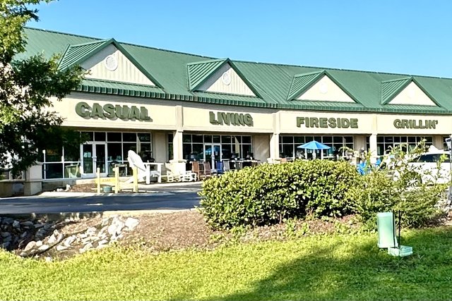 Casual Living in Bluffton — CASUAL LIVING FIRESIDE GRILLIN' across the green-roofed front, Adirondack chairs out on display
