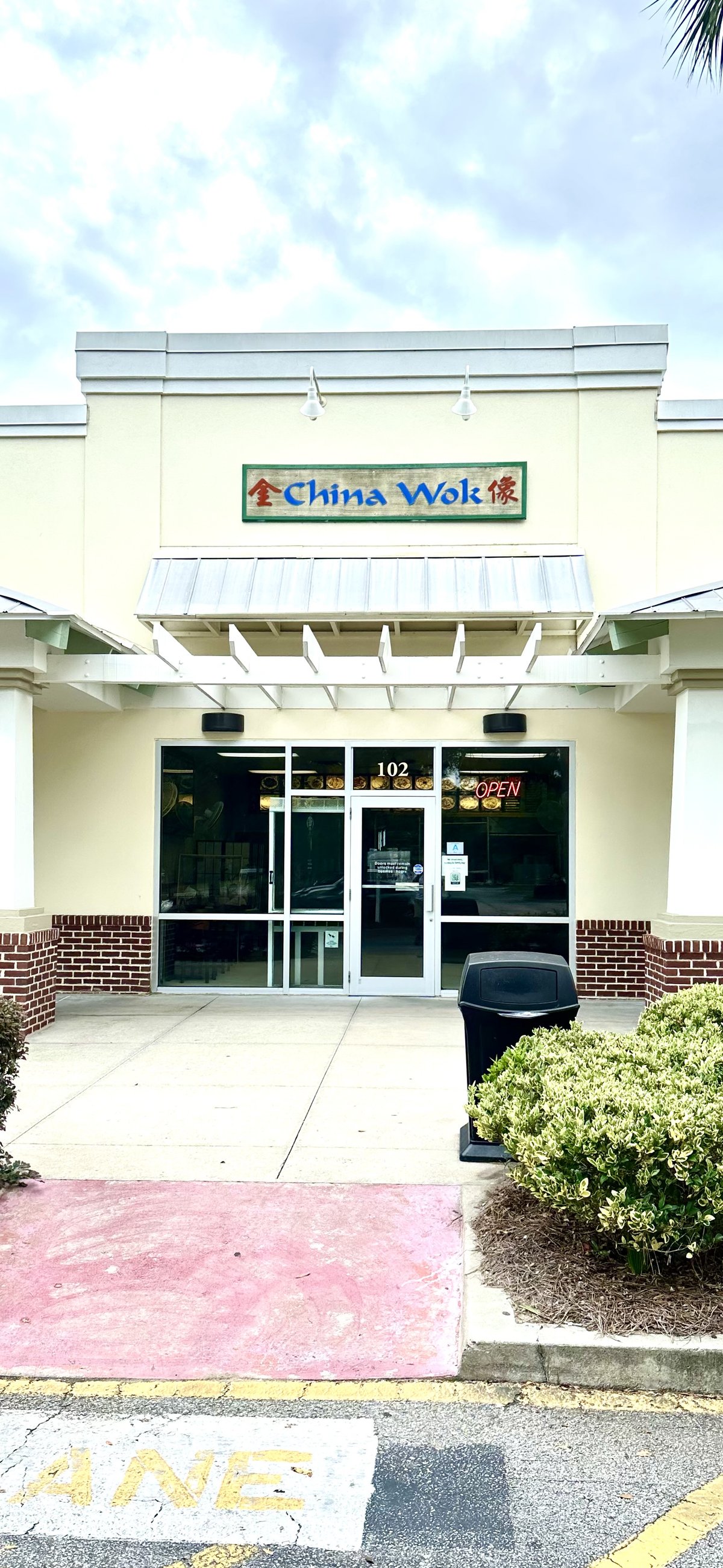 China Wok storefront in Bluffton, head-on — the sign over unit 102, pergola and OPEN sign