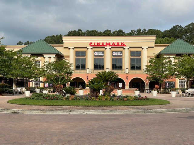 The Cinemark theater in Bluffton — red letters over the arched front, palms and a flower circle on the plaza