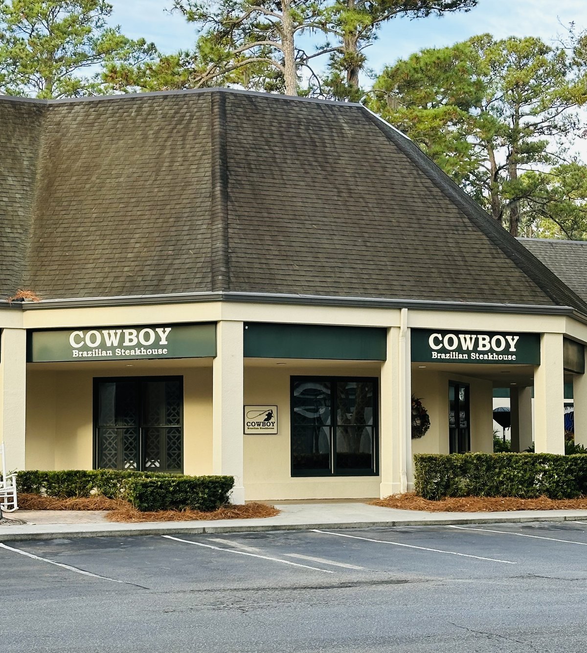 Cowboy Brazilian Steakhouse at Sea Pines Circle, Hilton Head Island — the corner building with the steep shingled roof and green signs