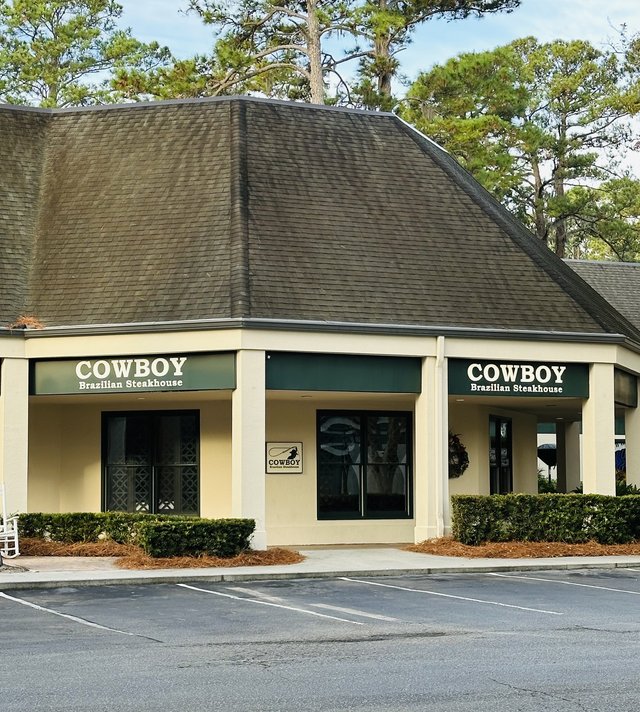 Cowboy Brazilian Steakhouse at Sea Pines Circle, Hilton Head Island — the corner building with the steep shingled roof and green signs