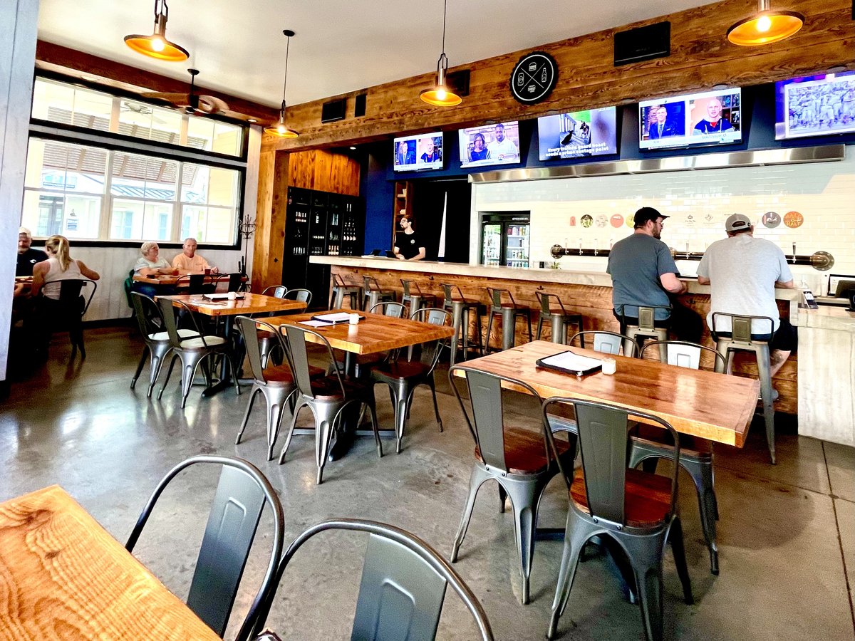 Craft Kitchen interior with long bar, beer taps, TVs and wood tables, Bluffton SC