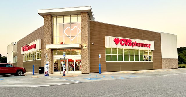 CVS Pharmacy on US 278 in Hardeeville — the red heart signs, stone pillars and a glowing heart in the front glass at dusk