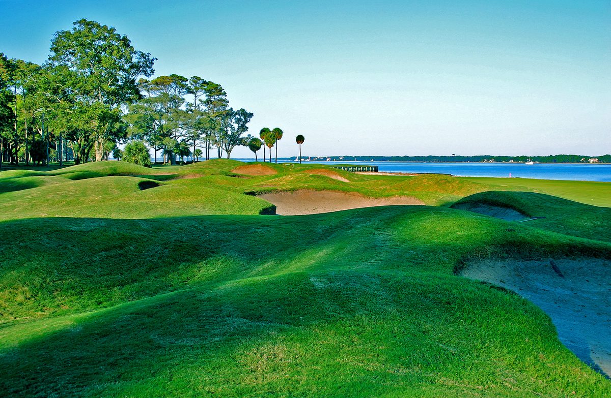 Rolling dunes and bunkers of the 18th fairway on Daufuskie Island, water beyond