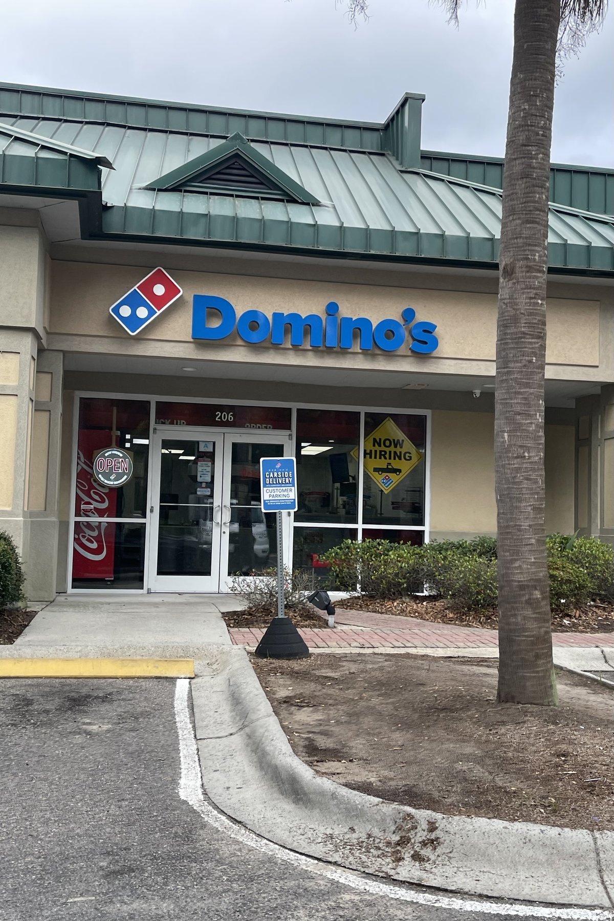 Domino's in Bluffton — the blue letters and domino tile over unit 206, a Now Hiring sign in the window