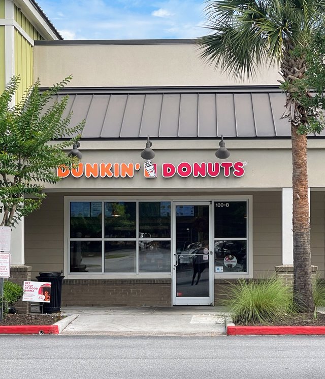 Dunkin' Donuts in Bluffton — orange and pink letters over unit 100-B, a palmetto by the door