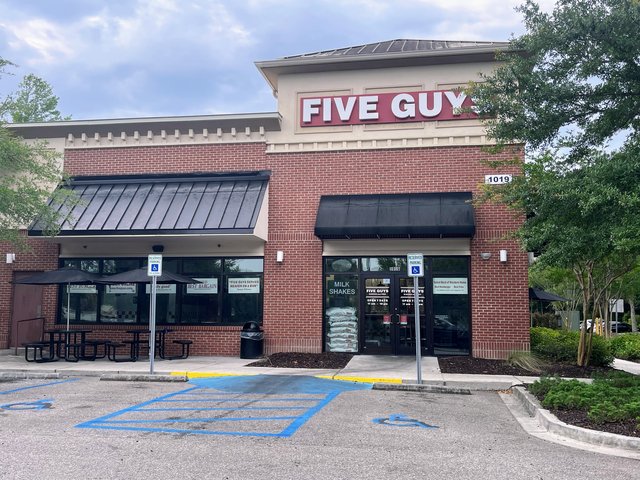 Five Guys storefront in red brick with potato sacks stacked in the window, Bluffton SC
