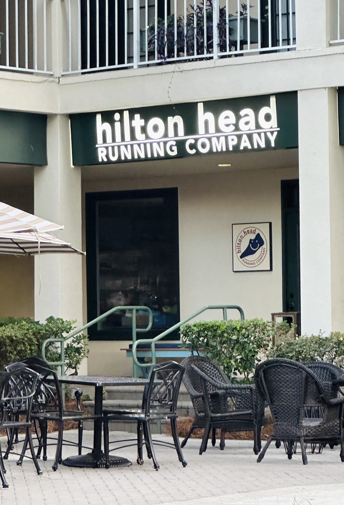 Hilton Head Running Company — the lowercase sign over the storefront, the smiling island logo and courtyard tables in front