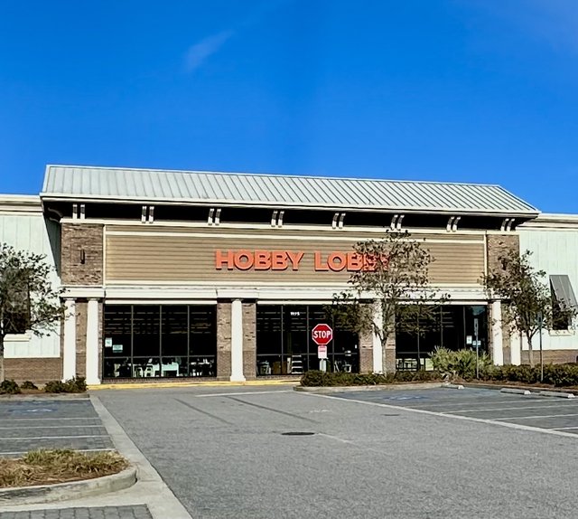 Hobby Lobby in Bluffton — big orange letters over the glass front, a stop sign in the drive and an empty Sunday-morning lot