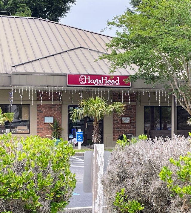 HogsHead Kitchen + Wine Bar red sign with barrel logo, icicle lights and a palmetto by the door, Bluffton SC
