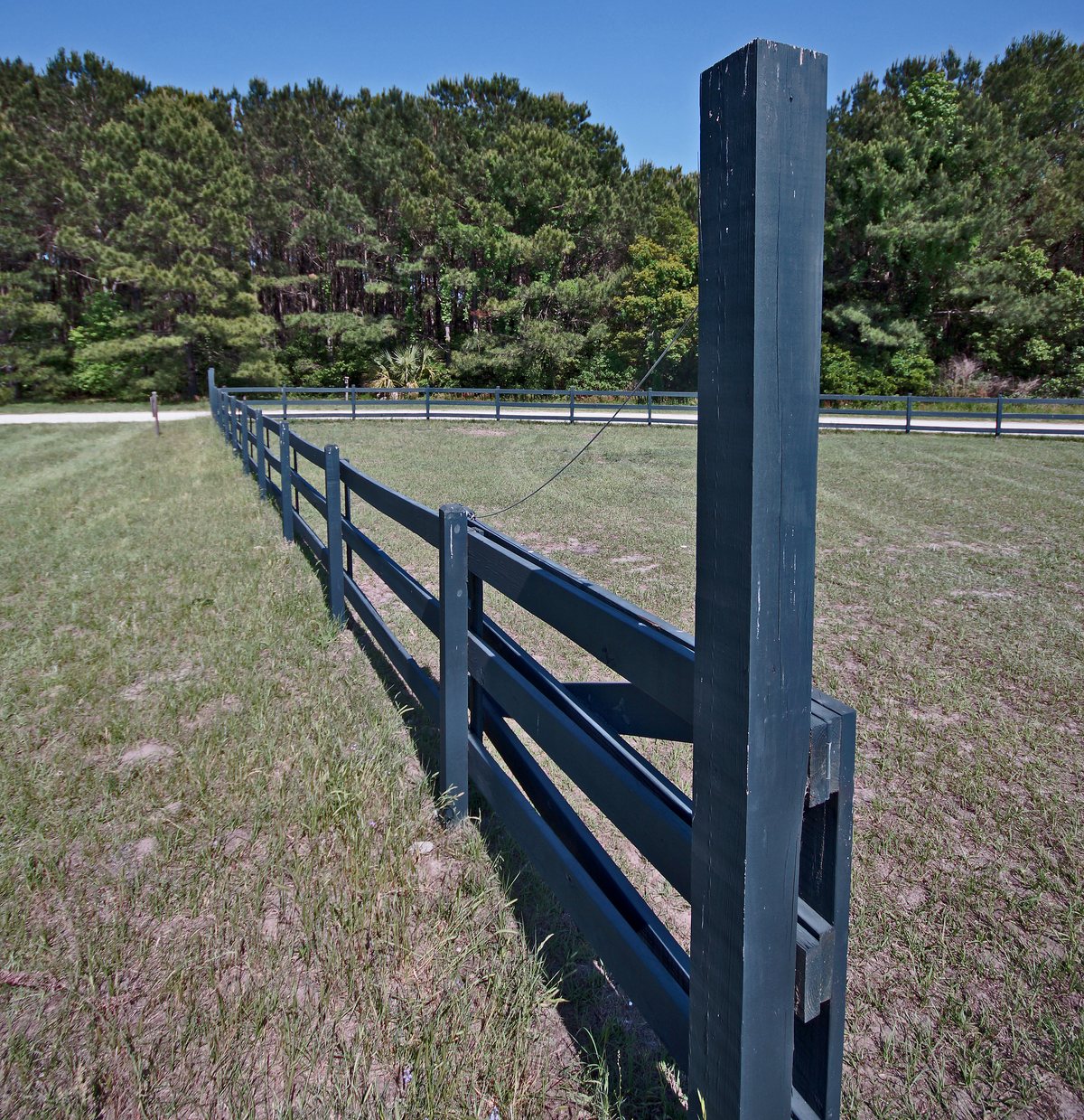 Pasture fence. The split-rail pasture fence running out across the grass.