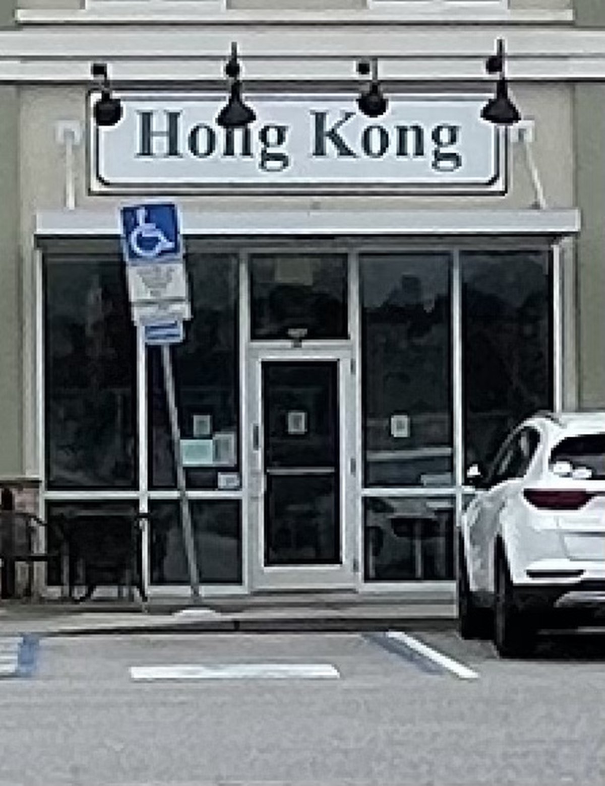 Hong Kong Chinese restaurant storefront in Buckwalter Place, Bluffton — serif sign over glass doors, a white SUV by the curb