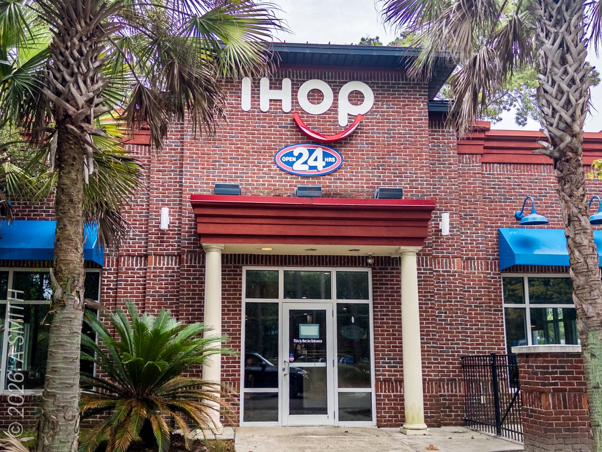 The IHOP entrance in October 2026 — the glass doors under the red 24-hour sign