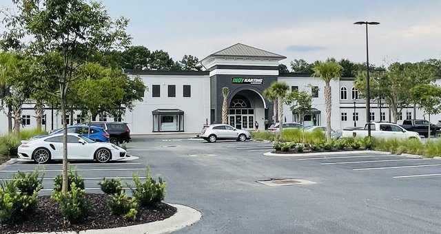 Indy Karting & Amusement in Belfair Towne Village, Bluffton — the big white building with the arched entrance, a white Porsche in the lot