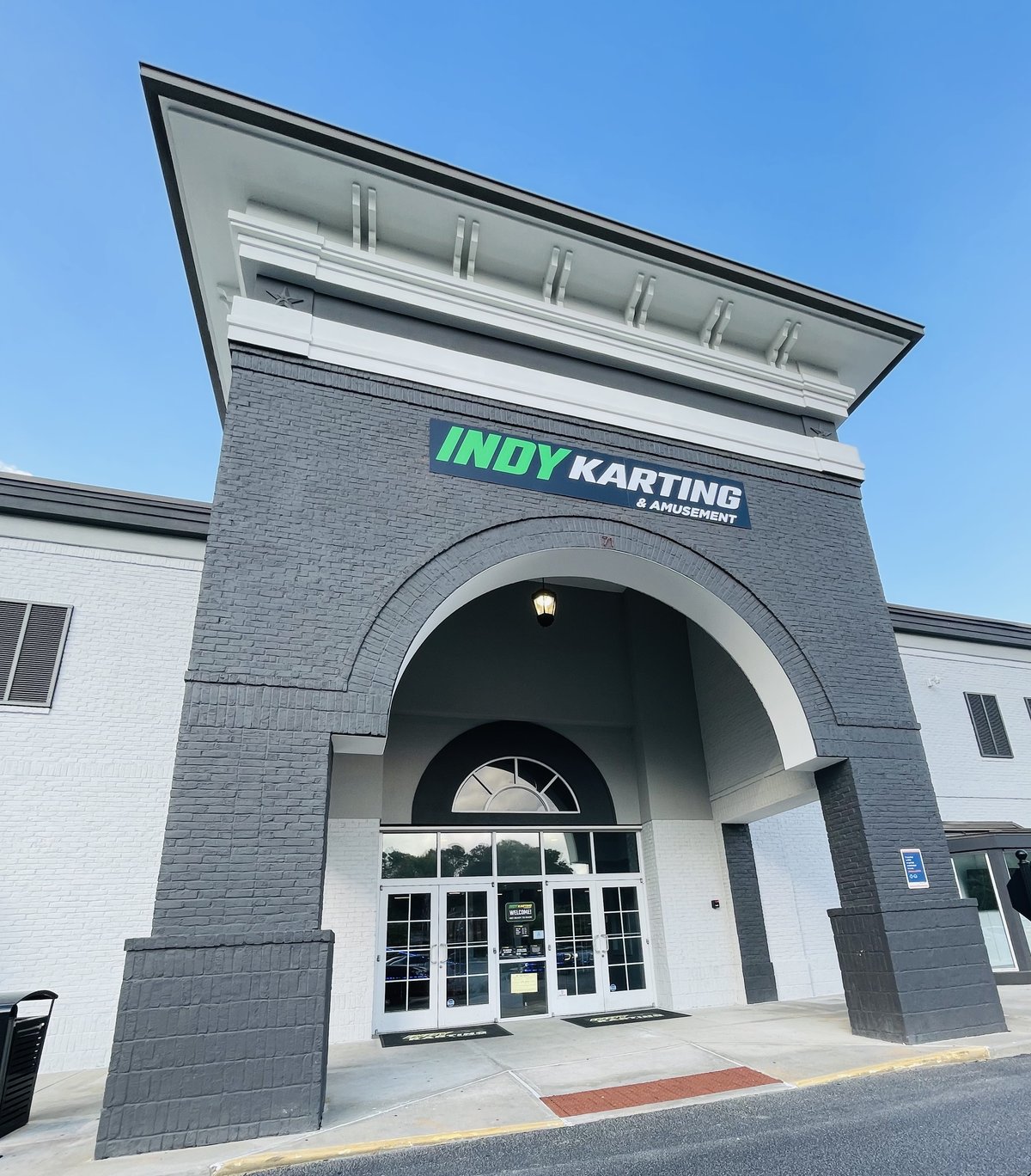 The entrance of Indy Karting & Amusement in Bluffton — the tall grey arch and glass doors