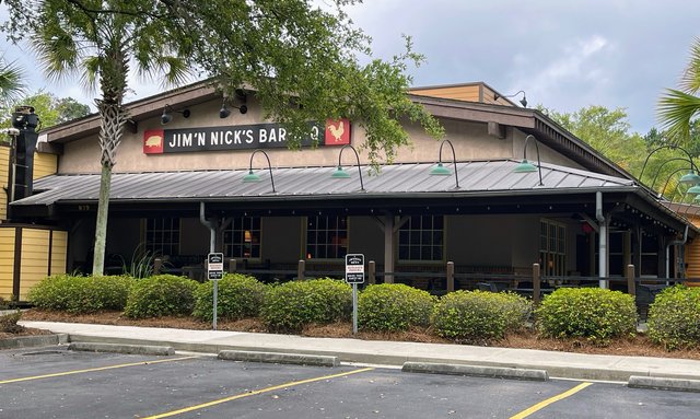 Jim 'N Nick's Bar-B-Q storefront with pig and rooster sign over a covered porch, Bluffton SC