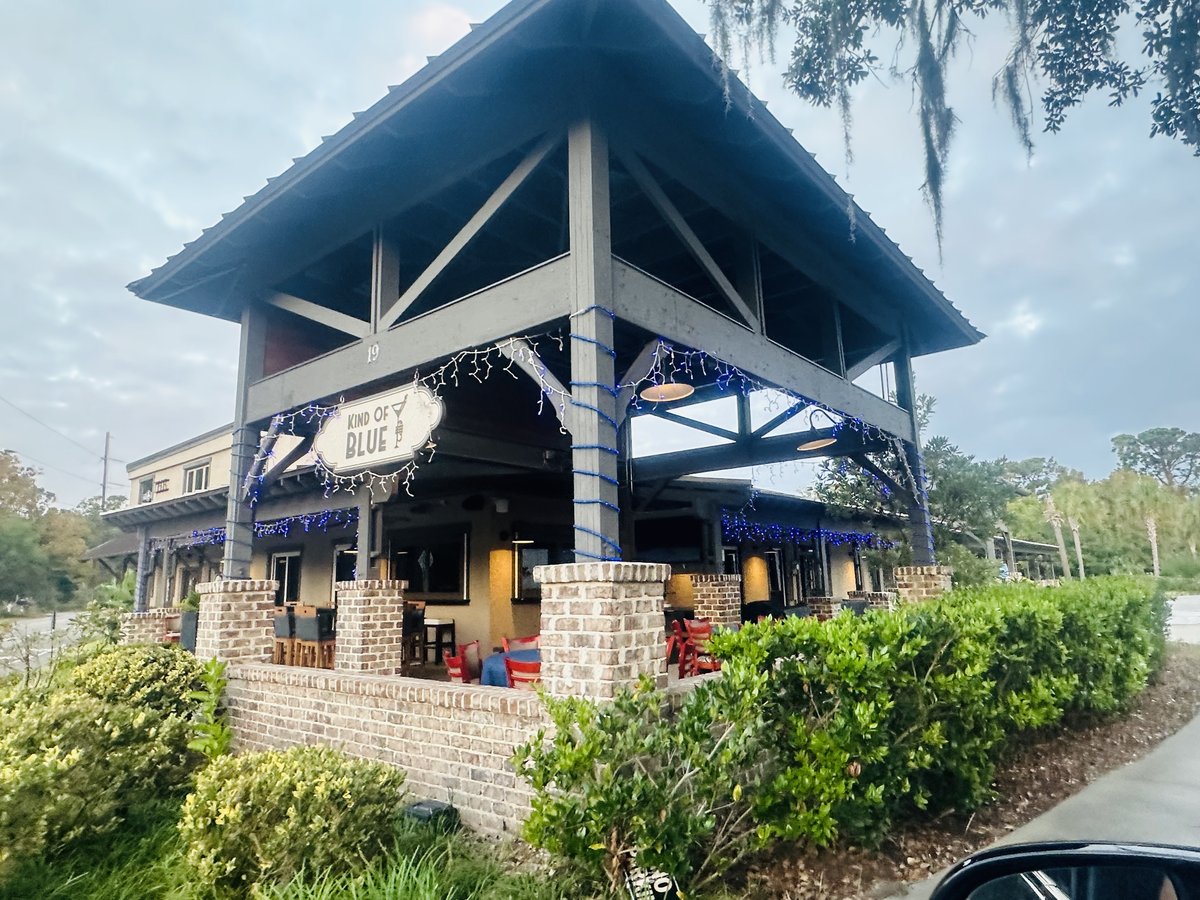 Kind of Blue on Hilton Head Island — the tall timber pavilion with its hanging sign, blue string lights and red chairs on the brick terrace
