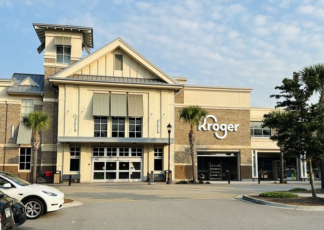 Kroger at Shelter Cove on Hilton Head Island — the gabled entrance, palmettos and a white Tesla in the lot