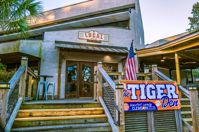 Local Pie on Hilton Head Island — the stucco building, wooden steps up to the deck and the Tiger Den banner on the rail