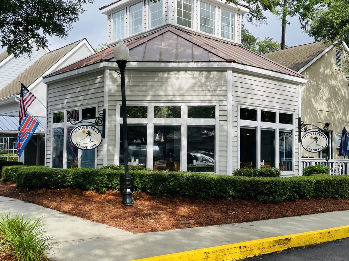Main Street Island Pub on Hilton Head Island — the corner tower building with cupola, flags and hedges on Main Street