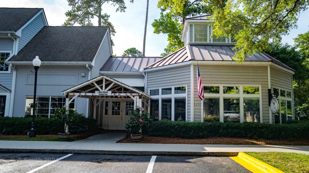 The entrance of Main Street Island Pub on Hilton Head Island — the covered porch, flag and the corner tower