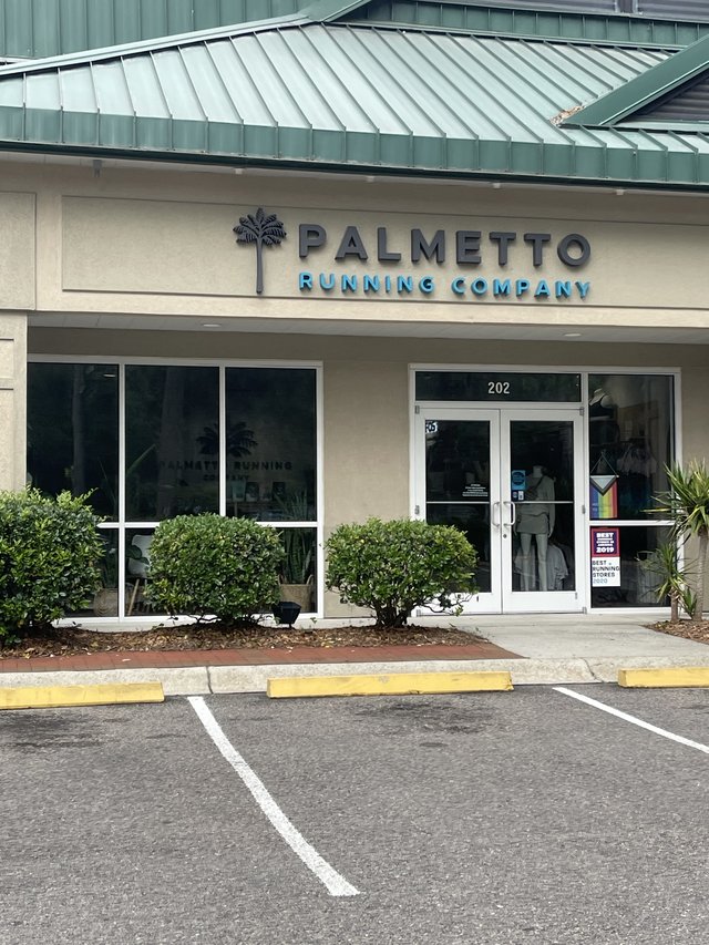 Palmetto Running Company in Bluffton — the palmetto logo and letters over unit 202, a runner mannequin in the door glass