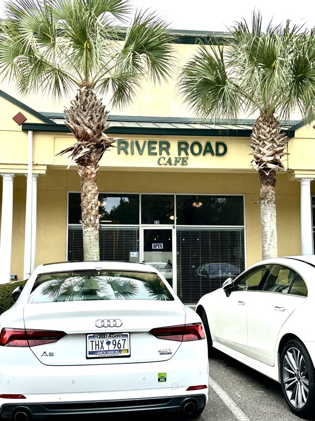 River Road Cafe in Bluffton — green letters over unit 20, a palmetto on each side of the sign