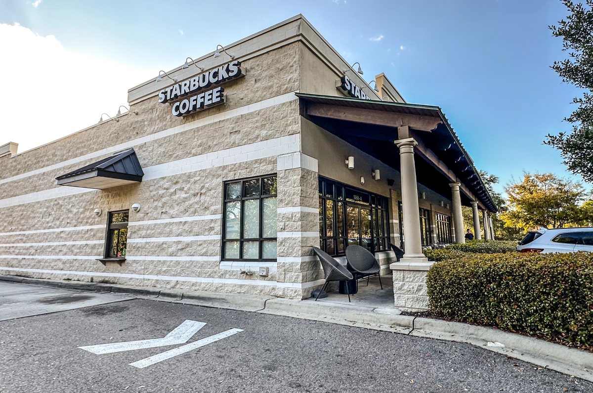 The Starbucks stone corner — the side wall, patio chairs, and the sign wrapping the corner