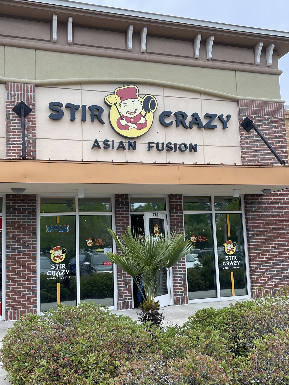 Stir Crazy Asian Fusion storefront in Bluffton — the chef mascot in the sign, neon OPEN in the window