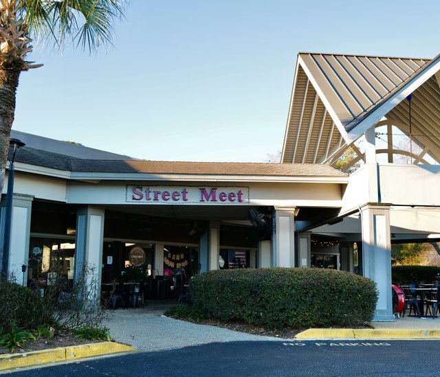 Street Meet restaurant entrance with patio tables under the gabled roof on Mathews Drive, Hilton Head Island