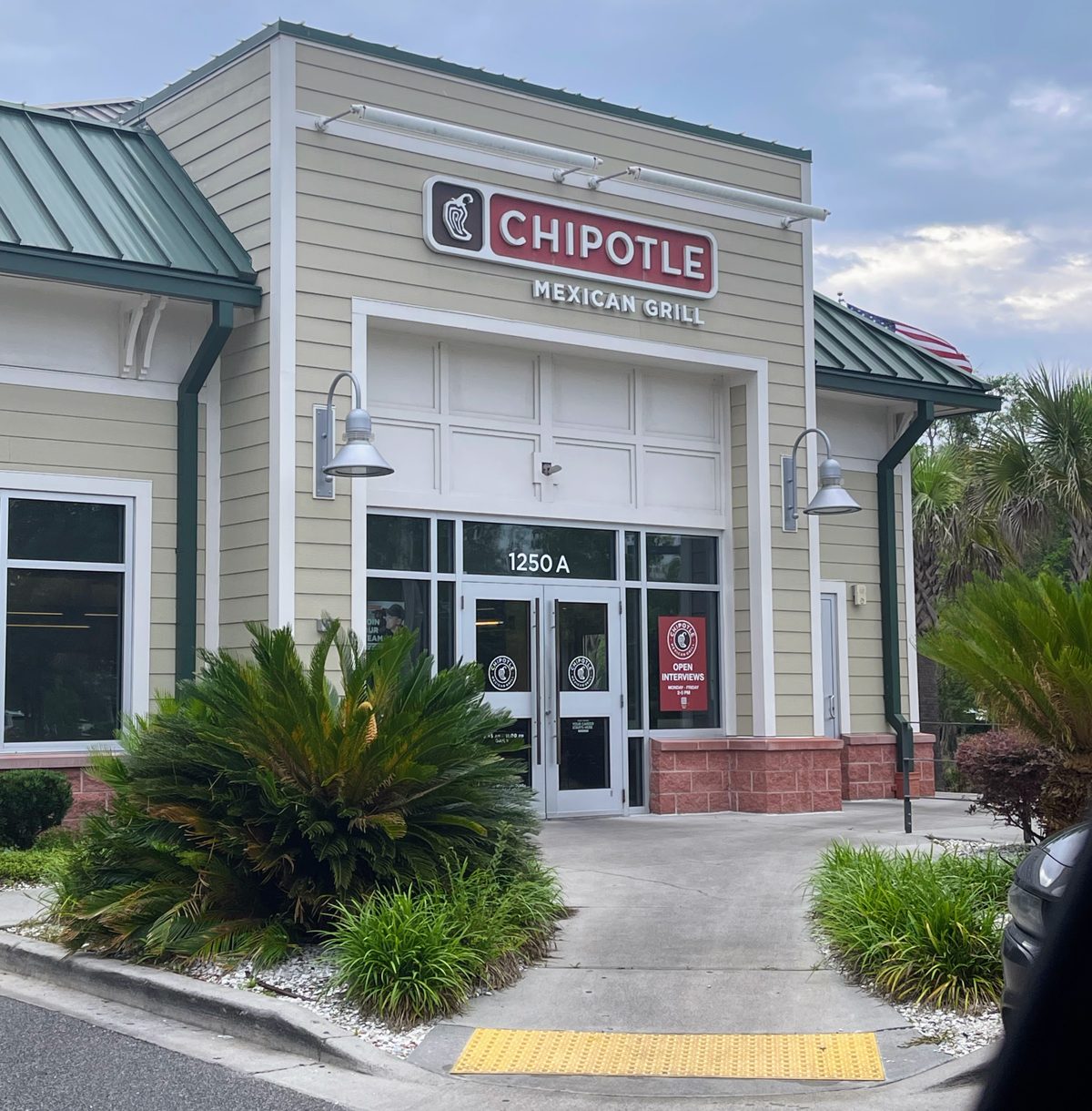 Chipotle Mexican Grill near Tanger Outlets 1 — red sign, green metal roof, sago palms at the door