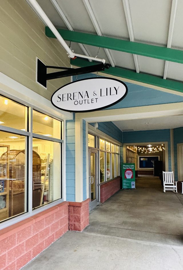 The oval Serena & Lily Outlet sign hanging over the covered walkway at Tanger Outlets 1