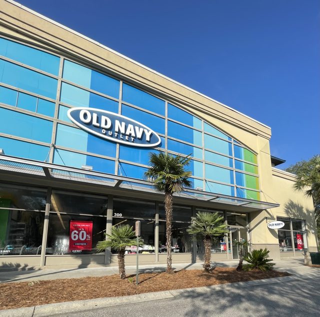 Old Navy Outlet at Tanger Outlets 2 — big blue-glass wall with the white oval logo, palms in front