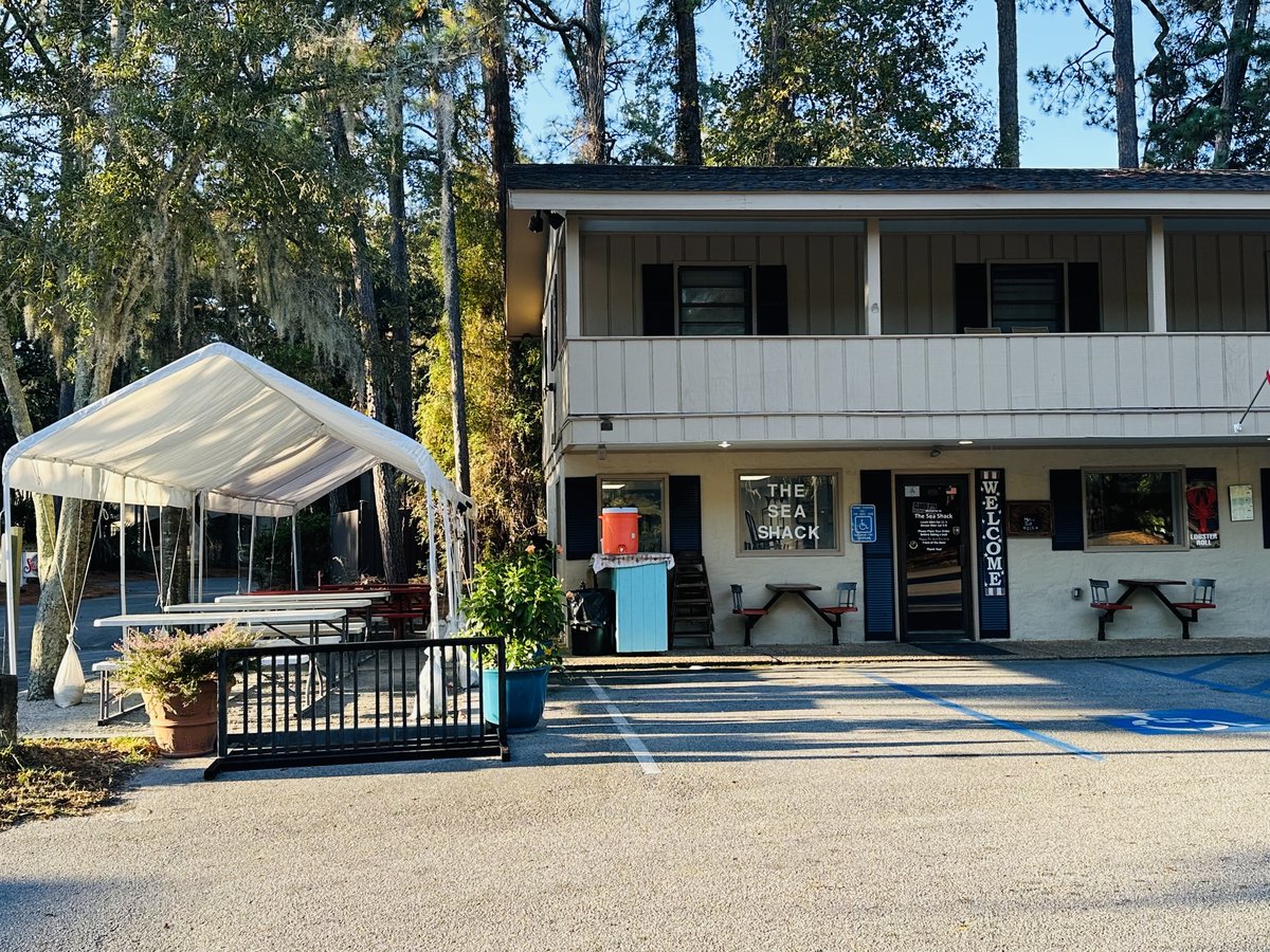 The Sea Shack on Pope Avenue, Hilton Head Island — the little ground-floor shack under a two-story building, picnic tables under a tent