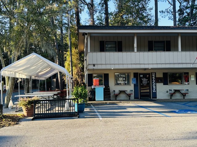 The Sea Shack on Pope Avenue, Hilton Head Island — the little ground-floor shack under a two-story building, picnic tables under a tent