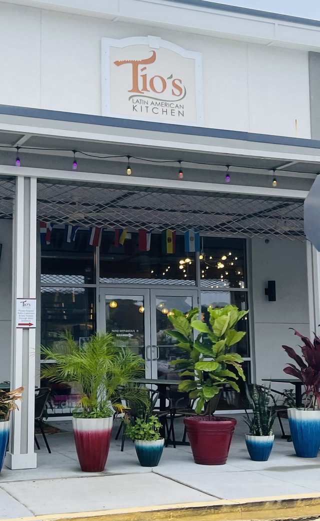 Tío's Latin American Kitchen in Buckwalter Place, Bluffton — the sign with the alligator in the letter T, flags and big planters on the patio