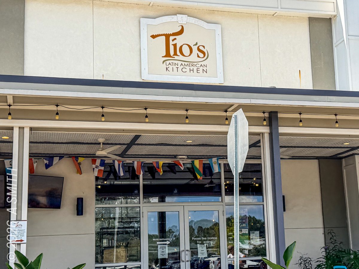 The Tio's Latin American Kitchen entrance in Buckwalter Place — the tiled sign, flag bunting, and string lights over the doors