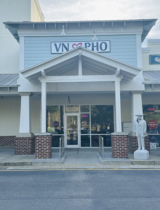 VN Pho storefront in Bluffton — the sign with a heart in the middle, white columns, a statue standing by the door