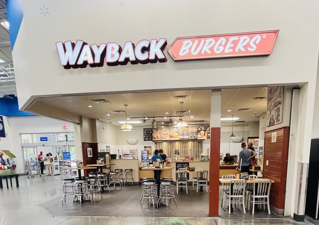 The Wayback Burgers counter inside the Bluffton Walmart — chrome stools, menu boards and the big red sign