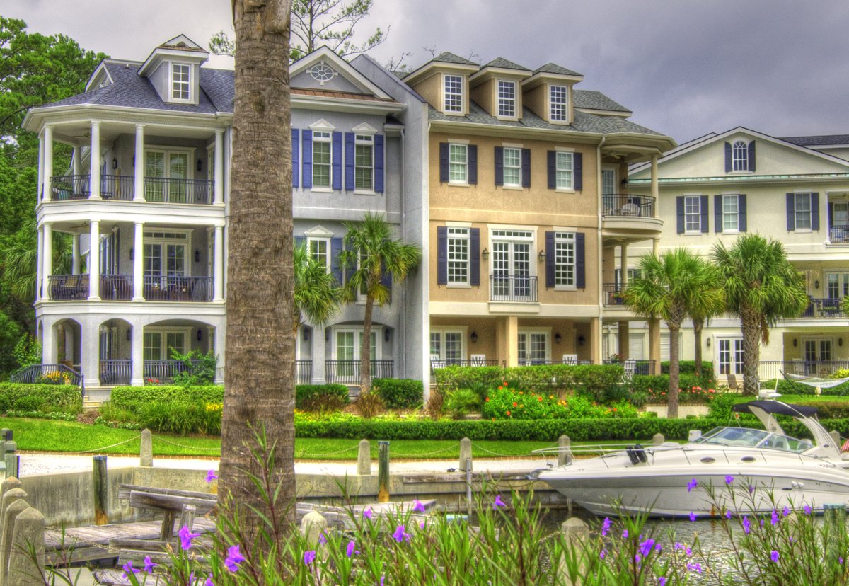 Harbour homes at Windmill Harbour — porches, palms, and a boat at the dock